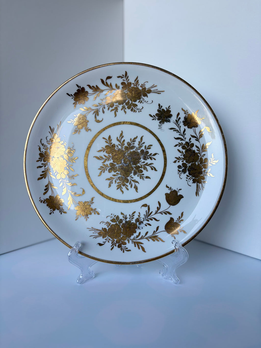Antique French porcelain cake plate, from Paris, teaturing intricate hand-decorated gold floral motits on a white background.