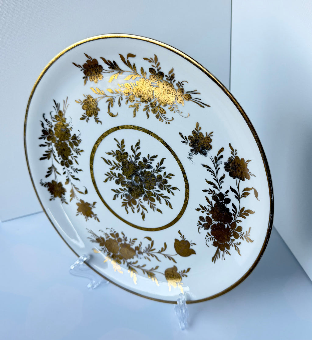Antique French porcelain cake plate, from Paris, teaturing intricate hand-decorated gold floral motits on a white background.