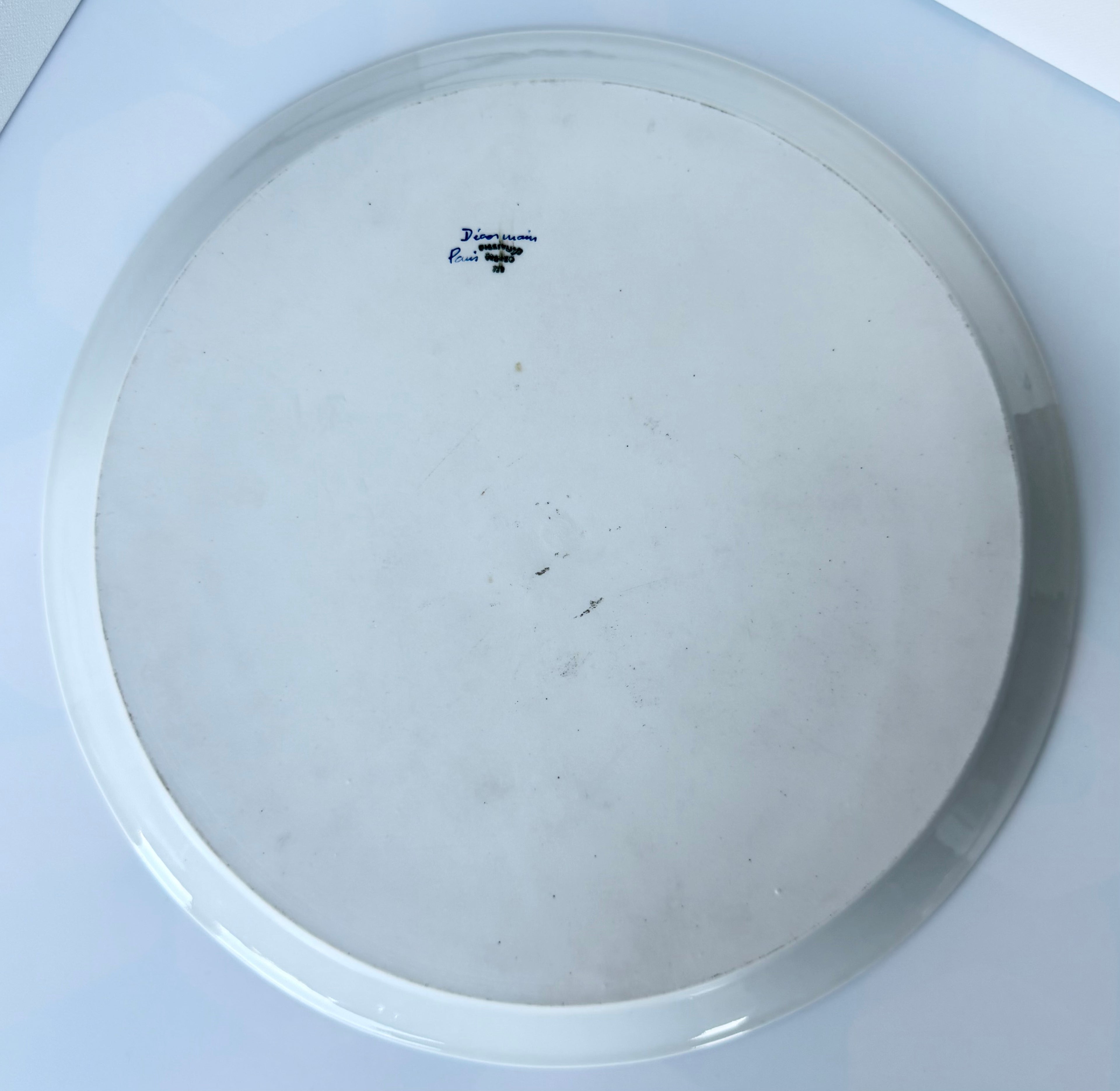 Antique French porcelain cake plate, from Paris, teaturing intricate hand-decorated gold floral motits on a white background.