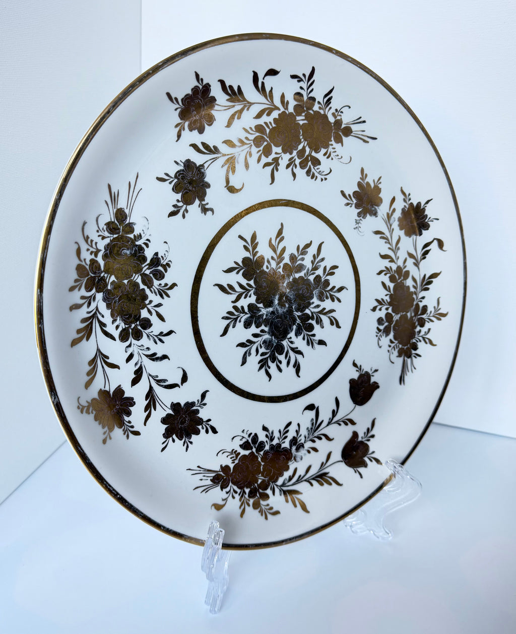 Antique French porcelain cake plate, from Paris, teaturing intricate hand-decorated gold floral motits on a white background.
